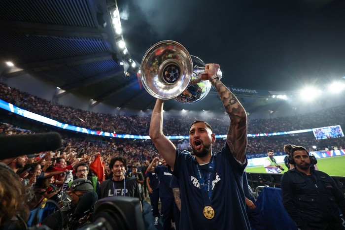 Soccer Football - Champions League - Paris St Germain Victory Parade - Paris, France - June 1, 2025 Paris St Germain's Gianluigi Donnarumma celebrates with supporters and teammates during a ceremony to present the trophy a day after the club won the UEFA Champions League. Pool via REUTERS/Frank Fife