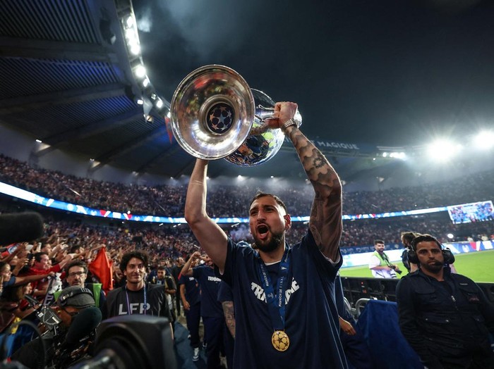 Soccer Football - Champions League - Paris St Germain Victory Parade - Paris, France - June 1, 2025  Paris St Germain's Gianluigi Donnarumma celebrates with supporters and teammates during a ceremony to present the trophy a day after the club won the UEFA Champions League. Pool via REUTERS/Frank Fife