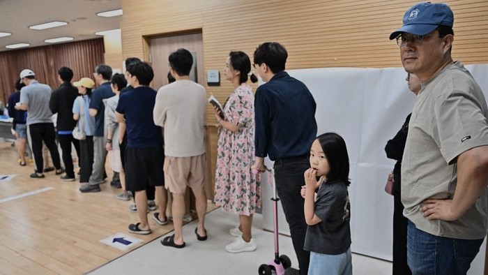 Para pemilih Korsel mengantre di salah satu tempat pemungutan bunyi sewaktu pilpres digelar pada Selasa (3/6) waktu setempat People queue to vote at a polling station during the presidential election in Seoul on June 3, 2025. (Photo by Pedro Pardo / AFP)