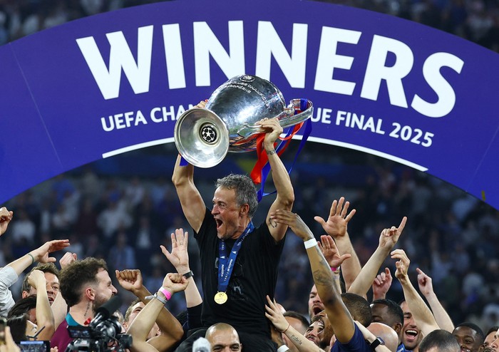 Soccer Football - Champions League - Final - Paris St Germain v Inter Milan - Allianz Arena, Munich, Germany - May 31, 2025 Paris St Germain coach Luis Enrique celebrates with the trophy and his players after winning the Champions League REUTERS/Kai Pfaffenbach