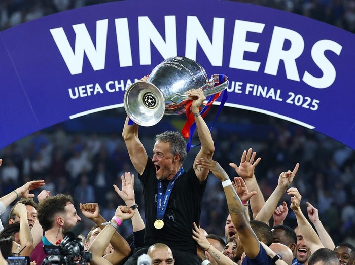 Soccer Football - Champions League - Final - Paris St Germain v Inter Milan - Allianz Arena, Munich, Germany - May 31, 2025 Paris St Germain coach Luis Enrique celebrates with the trophy and his players after winning the Champions League REUTERS/Kai Pfaffenbach
