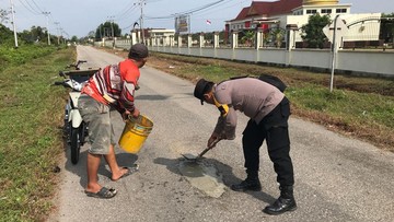 Sigap! Polisi Turun Perbaiki Jalan Berlubang di Meranti Riau