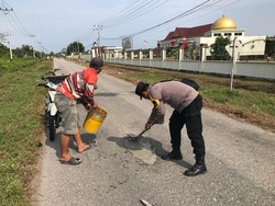Sigap! Polisi Turun Perbaiki Jalan Berlubang di Meranti Riau
