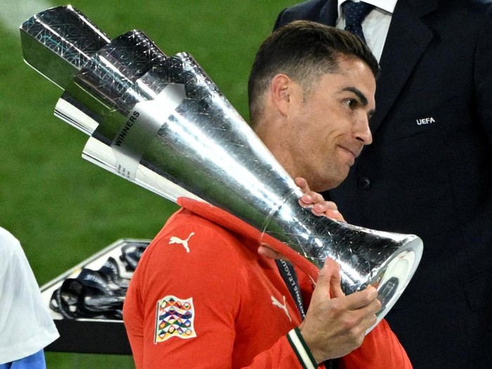 Soccer Football - Nations League - Final - Portugal v Spain - Allianz Arena, Munich, Germany - June 9, 2025 Portugal's Cristiano Ronaldo collects the trophy from UEFA president Aleksander Ceferin after winning the Nations League REUTERS/Annegret Hilse     TPX IMAGES OF THE DAY