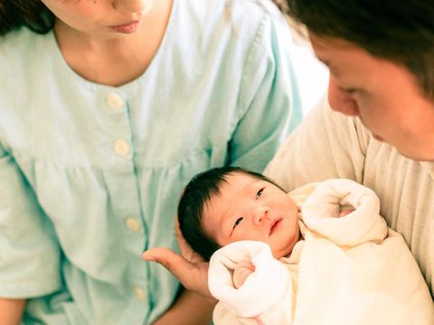 Japanese parents looking their newborn baby at the hospital