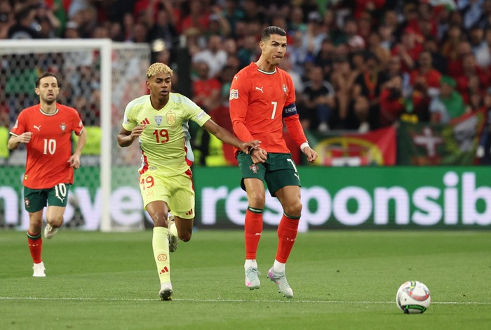 Lamine Yamal, Cristiano Ronaldo Soccer Football - Nations League - Final - Portugal v Spain - Allianz Arena, Munich, Germany - June 8, 2025 Spains Lamine Yamal in action with Portugals Cristiano Ronaldo REUTERS/Michaela Stache