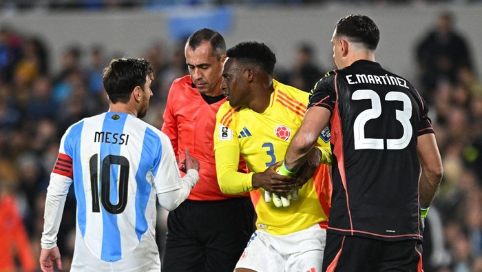 Soccer Football - World Cup - South American Qualifiers - Argentina v Colombia - Estadio Monumental, Buenos Aires, Argentina - June 10, 2025 Argentinas Lionel Messi and Emiliano Martinez with Colombias Jhon Lucumi as referee Juan Benitez looks on REUTERS/Rodrigo Valle