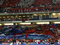 Dukungan total suporter Indonesia kembali mencuri perhatian, kali ini saat laga kualifikasi Piala Dunia melawan Jepang di Suita City Stadium, Rabu (10/6/2025). Meski bertandang ke kandang lawan, suporter Garuda tetap tampil militan dengan mengibarkan tifo besar berwarna merah putih saat lagu kebangsaan dikumandangkan. (REUTERS/Issei Kato) 