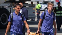 Bek Atletico Madrid, Cesar Azpilicueta dan Pablo Barrios, menenteng kopernya di landasan bandara. Los Colchoneros akan langsung memainkan laga pertamanya melawan PSG, Senin (16/6) WIB. (Foto: DANIEL COLE/REUTERS)