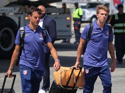 Bek Atletico Madrid, Cesar Azpilicueta dan Pablo Barrios, menenteng kopernya di landasan bandara. Los Colchoneros akan langsung memainkan laga pertamanya melawan PSG, Senin (16/6) WIB. (Foto: DANIEL COLE/REUTERS)