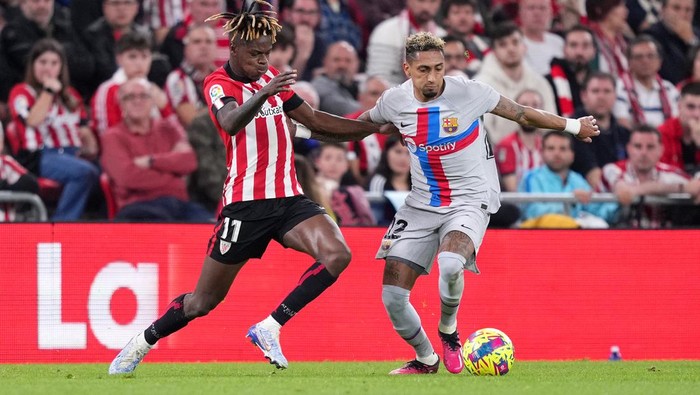 BILBAO, SPAIN - MARCH 12: Raphinha of FC Barcelona is challenged by Nico Williams of Athletic Club during the LaLiga Santander match between Athletic Club and FC Barcelona at San Mames Stadium on March 12, 2023 in Bilbao, Spain. (Photo by Juan Manuel Serrano Arce/Getty Images)