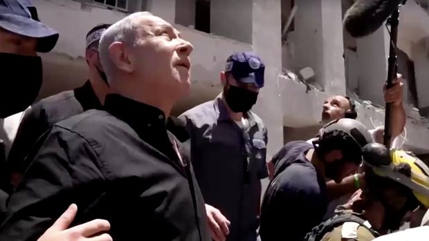 Perdana Menteri Israel Benjamin Netanyahu mengunjungi letak wilayah permukiman nan hancur akibat serangan rudal Iran di dekat Tel Aviv, Israel, Minggu (15/6/2025). (Tangkapan Layar Video/REUTERS)