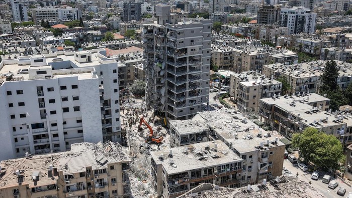 Emergency personnel work at an impact site after missiles were launched from Iran to Israel, in Tel Aviv, Israel, June 16, 2025. REUTERS/Ronen Zvulun Institut Weizmann