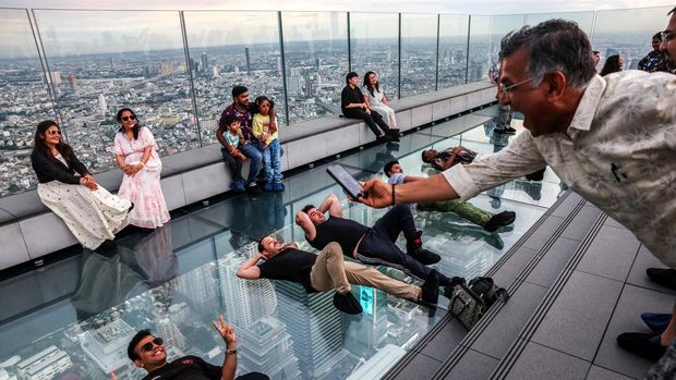 Tourists pose as they enjoy the Mahanakhon Skywalk Rooftop at Mahanakhon building in Bangkok, Thailand, May 15, 2025. REUTERS/Athit Perawongmetha