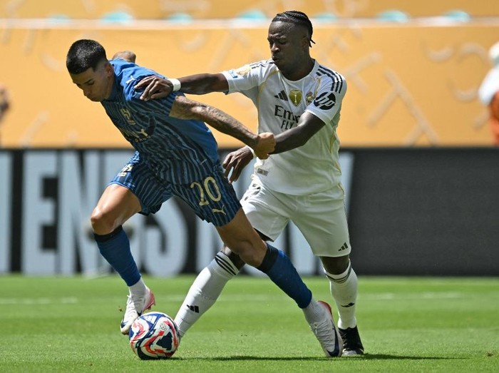Al Hilals Portuguese defender #20 Joao Cancelo (L) fights for the ball with Real Madrids Brazilian forward #07 Vinicius Junior during the FIFA Club World Cup 2025 Group H football match between Spains Real Madrid and Saudis Al-Hilal at the Hard Rock stadium in Miami on June 18, 2025. (Photo by CHANDAN KHANNA / AFP)