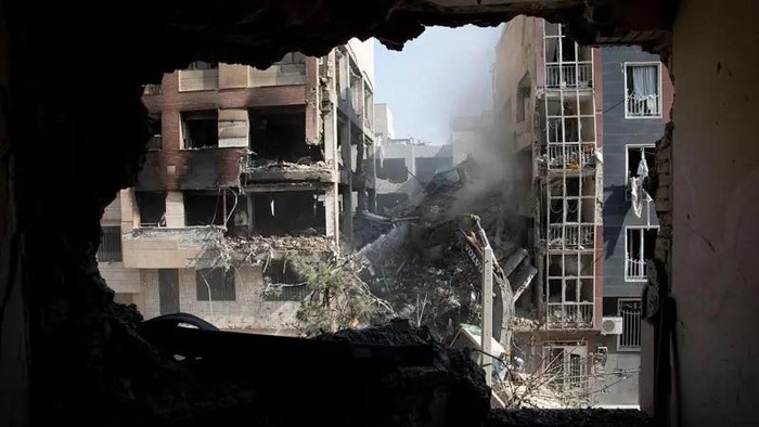 Pemandangan dari ruang keluarga suatu bangunan hunian yang hancur jawaban serangan Israel di Teheran, Iran, pada 13 Juni 2025. (MAJID SAEEDI/GETTY IMAGES)