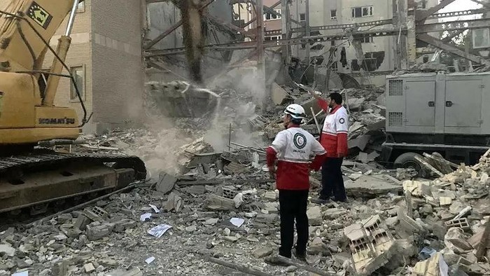 This handout picture provided by the Iranian Red Crescent on June 19, 2025 shows members of their rescue teams clearing debris at a building destroyed during an Israeli attack in Tehran. (AFP)
