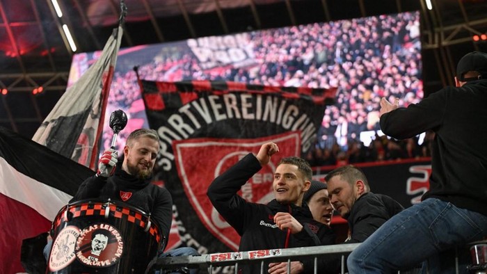Florian Wirtz Bayer Leverkusens German midfielder #10 Florian Wirtz (C) celebrates with the Ultras after extra-time of the German Cup (DFB Pokal) quarter-final football match Bayer 04 Leverkusen vs FC Cologne in Leverkusen, western Germany on February 5, 2025. (Photo by INA FASSBENDER / AFP) / DFB REGULATIONS PROHIBIT ANY USE OF PHOTOGRAPHS AS IMAGE SEQUENCES AND QUASI-VIDEO.