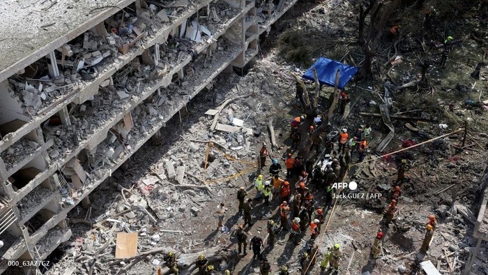 Pasukan keselamatan Israel dan petugas tanggap darurat berkumpul di lokasi serangan Iran yang memukul kawasan permukiman di kawasan Ramat Aviv di Tel Aviv pada 22 Juni 2025. Setidaknya 16 orang terluka dan setidaknya satu imbas dilaporkan di Israel penggalan tengah sehabis Iran meluncurkan dua gelombang rudal ke negara itu menyusul pengeboman AS terhadap lokasi nuklirnya, menurut  layanan evakuasi dan laporan.