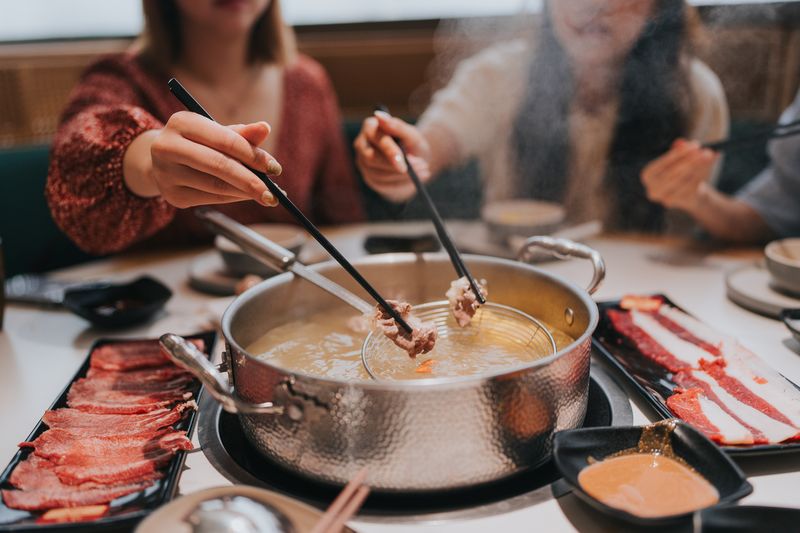Happy Generation Z girls tavelling  in Zhuhai, Greater Bay Area, China, and having hotpot in a restaurant