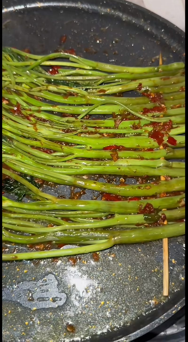 Food vlogger mencicip sate kangkung yang sedang viral di media sosial.