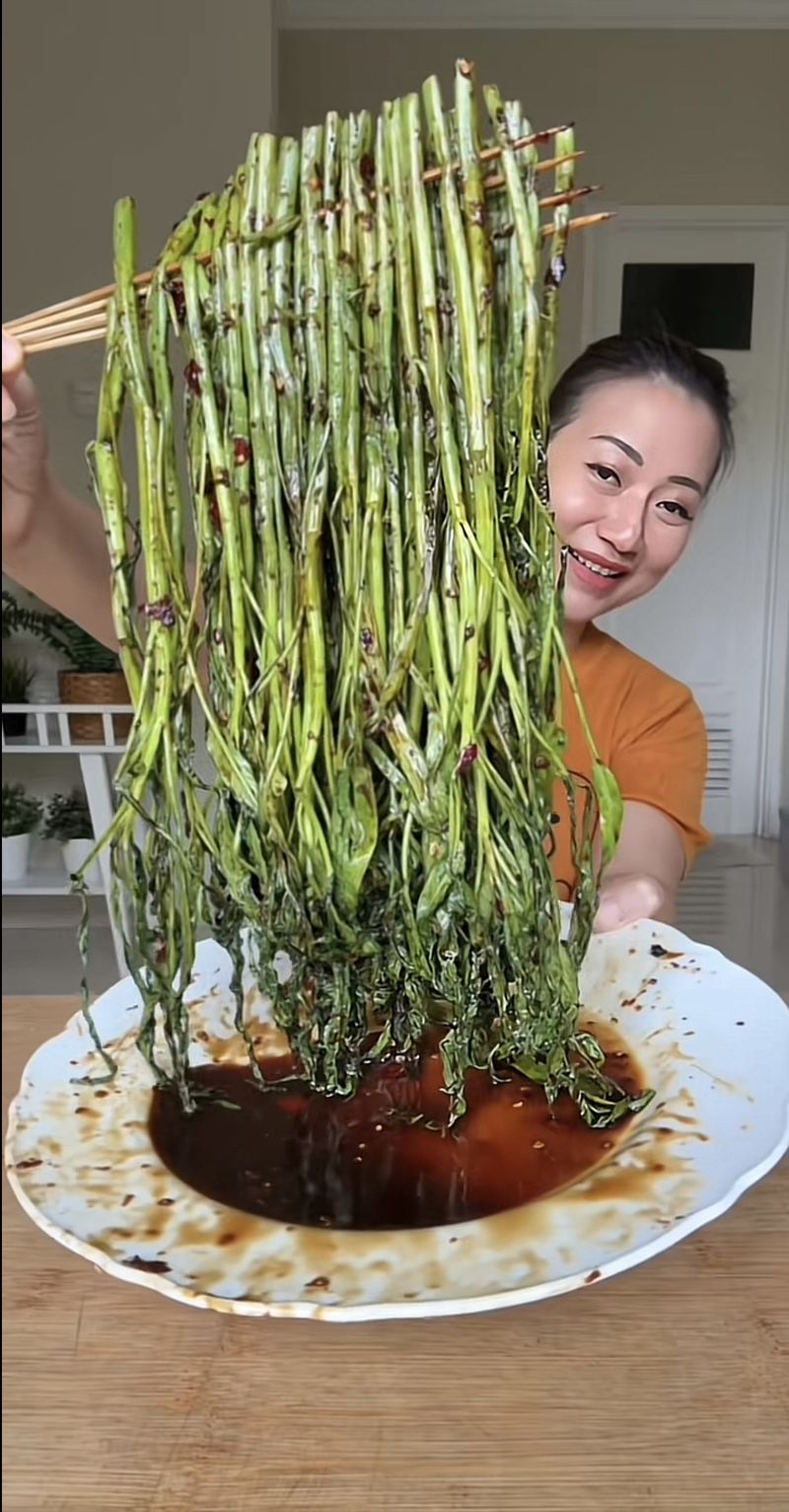 Food vlogger mencicip sate kangkung yang sedang viral di media sosial.