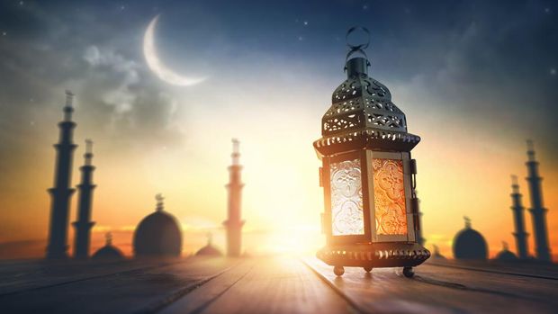 Ornamental Arabic lantern with burning candle glowing at night. Festive greeting card, invitation for Muslim holy month bulan puasa Kareem.