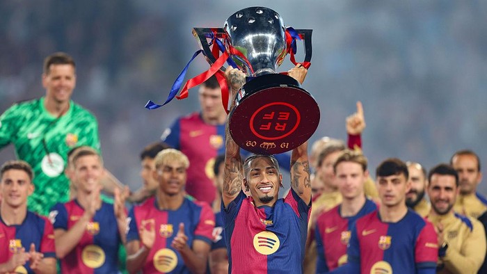 BARCELONA, SPAIN - MAY 18: Raphinha of FC Barcelona lifts the La Liga EA Sports title trophy following the La Liga EA Sports match between FC Barcelona and Villarreal CF at Estadi Olimpic Lluis Companys on May 18, 2025 in Barcelona, Spain. (Photo by Flor Tan Jun/Getty Images)