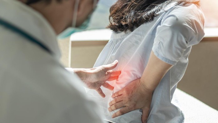 Lower back pain, back ache, muscle or spine injury in menopause woman patient with backache from osteoporosis disease or office syndrome seeing orthopedic surgical doctor for medical treatment nyeri pinggang kiri