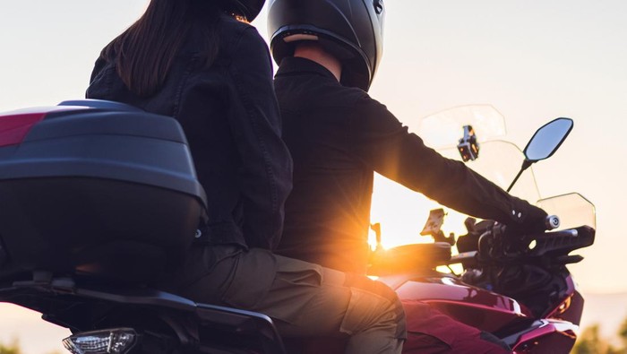Ilustrasi naik motor Motorcycling couple enjoys on country road at sunset