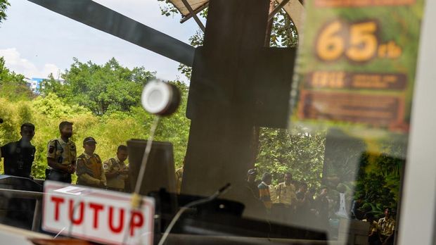 Petugas berjaga di depan loket pembelian tiket yang ditutup di Kebun Binatang Bandung, Jawa Barat, Kamis (3/7/2025). Akibat adanya dualisme kepengelolaan, tata kelola Bandung Zoo menutup operasional kebun hewan untuk sementara hingga waktu yang belum ditentukan. ANTARA FOTO/Raisan Al Farisi