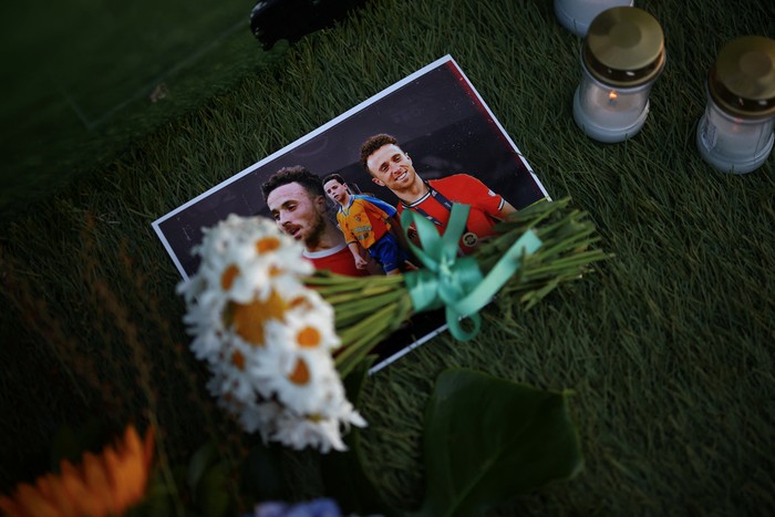 Flowers lie on photographs of Liverpools Portuguese soccer player Diogo Jota, who died in a car crash near Zamora, Spain, outside Gondomar stadium in Gondomar, Portugal, July 3, 2025. REUTERS/Pedro Nunes