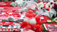 Sejak pagi, para suporter berdatangan dan memenuhi area depan stadion sambil membawa karangan bunga, syal, jersey, serta lilin yang diletakkan di sekitar gerbang utama Anfield, Sabtu (5/7). REUTERS/Temilade Adelaja