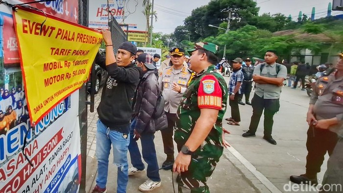 Polisi dan Tentara Nasional Indonesia mengatur parkir liar dengan harga tak masuk akal di sekeliling Stadion Si Jalak Harupat. Polisi dan Tentara Nasional Indonesia mengatur parkir liar dengan harga tak masuk akal di sekeliling Stadion Si Jalak Harupat.