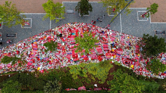 A drone view shows people looking at floral tributes left outside Anfield Stadium following the death of Liverpool Football Club soccer player Diogo Jota, in Liverpool, Britain, July 7, 2025. REUTERS/Phil Noble REFILE - CORRECTING SURNAME FROM 