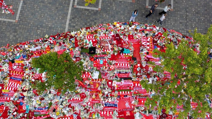 Foto Udara Karangan Bunga untuk Diogo Jota Banjiri Halaman Anfield A drone view shows people looking at floral tributes left outside Anfield Stadium following the death of Liverpool Football Club soccer player Diogo Jota, in Liverpool, Britain, July 7, 2025. REUTERS/Phil Noble REFILE - CORRECTING SURNAME FROM