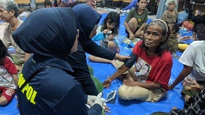 Polisi turun membantu warga terdampak banjir di Kebon Pala, Jakarta Timur, Senin (7/7/2025). Polisi mendirikan dapur lapangan hingga pelayanan kesehatan kepada warga tedampak banjir.