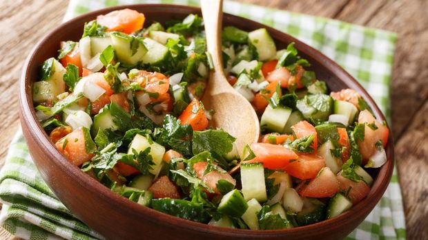 Shirazi salad (Iran) Shirazi salad of cucumbers, tomatoes, onions and herbs close-up in a bowl on the table. horizontal