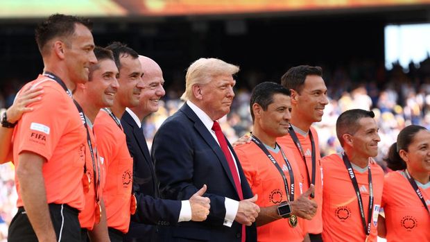 U.S. President Donald Trump and FIFA president Gianni Infantino pose for a photo with referee Alireza Faghani and match officials after Chelsea won against Paris St Germain in the FIFA Club World Cup final, at the MetLife Stadium in East Rutherford, New Jersey, U.S., July 13, 2025. REUTERS/Kevin Lamarque/Pool