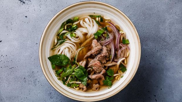 Pho Bo vietnamese Soup with beef in bowl on concrete background