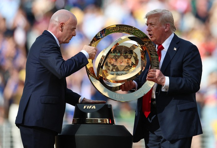 Soccer Football - FIFA Club World Cup - Final - Chelsea v Paris St Germain - MetLife Stadium, East Rutherford, New Jersey, U.S. - July 13, 2025 FIFA president Gianni Infantino and President Donald Trump carry the FIFA Club World Cup trophy during the