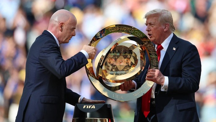 Soccer Football - FIFA Club World Cup - Final - Chelsea v Paris St Germain - MetLife Stadium, East Rutherford, New Jersey, U.S. - July 13, 2025 FIFA president Gianni Infantino and President Donald Trump carry the FIFA Club World Cup trophy during the presentation REUTERS/Hannah Mckay