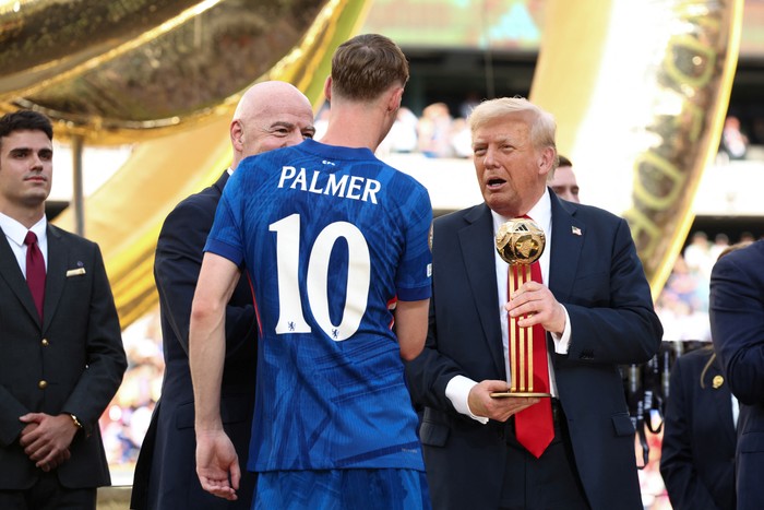 U.S. President Donald Trump presents Chelseas Cole Palmer with the golden ball trophy next to FIFA president Gianni Infantino after Chelsea won against Paris St Germain in the FIFA Club World Cup final, at the MetLife Stadium in East Rutherford, New Jersey, U.S., July 13, 2025. REUTERS/Kevin Lamarque/Pool
