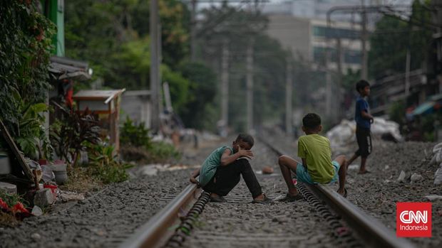 Warga beraktivitas di permukiman bantaran rel kereta api kawasan Pejompongan, Jakarta, Rabu (16/7/2025). (CNN Indonesia/Adi Ibrahim)