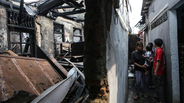 Warga melihat kondisi rumah yang telah hangus terbakar di Jalan Kutilang, Bukit Duri, Tebet, Jakarta Selatan, Sabtu (19/7/2025). Bedasarkan data Suku Dinas Pemadam Kebakaran Jakarta Selatan kebakaran yang melanda tiga rumah kontrakan mengakibatkan sebanyak empat orang meninggal dunia dan empat orang luka-luka. ANTARA FOTO/Asprilla Dwi Adah/nz