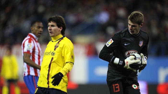 FC Barcelonas Argentinian forward Lionel Messi (L) reacts after being stopped by Atletico Madrids goalkeeper De Gea during their Spanish League football match at Vicente Calderon stadium in Madrid on February 14, 2010. AFP PHOTO / PIERRE-PHILIPPE MARCOU (Photo by PIERRE-PHILIPPE MARCOU / AFP)