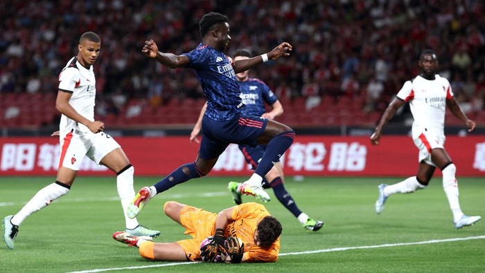 SINGAPORE, SINGAPORE - JULY 23: Pietro Terracciano of AC Milan makes a save at the feet of Bukayo Saka of Arsenal during the Pre-Season Friendly match between Arsenal FC and AC Milan at National Stadium on July 23, 2025 in Singapore. (Photo by Yong Teck Lim/Getty Images)