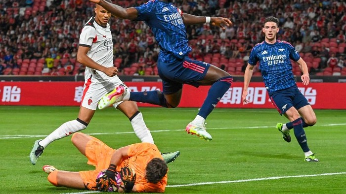 AC Milans goalkeeper Pietro Terracciano (bottom) saves the ball from Arsenals Bukayo Saka during the Singapore Festival of Football pre-season friendly match between Arsenal and AC milan at the National Stadium in Singapore on July 23, 2025. (Photo by Roslan RAHMAN / AFP)