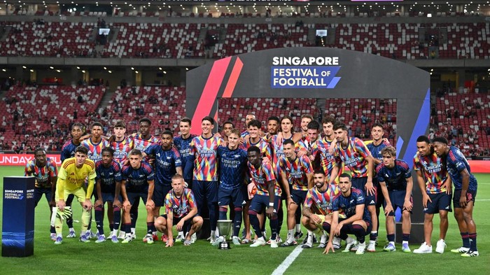 Soccer Football - Pre-Season Friendly - Arsenal v AC Milan - National Stadium, Singapore - July 23, 2025 Arsenal players pose with a trophy on the pitch after the match REUTERS/Caroline Chia