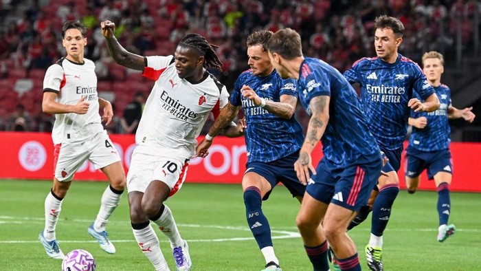 AC Milans Rafael Leao (2nd L) dribbles past Arsenal players during the Singapore Festival of Football pre-season friendly match between Arsenal and AC Milan at the National Stadium in Singapore on July 23, 2025. (Photo by Roslan RAHMAN / AFP)